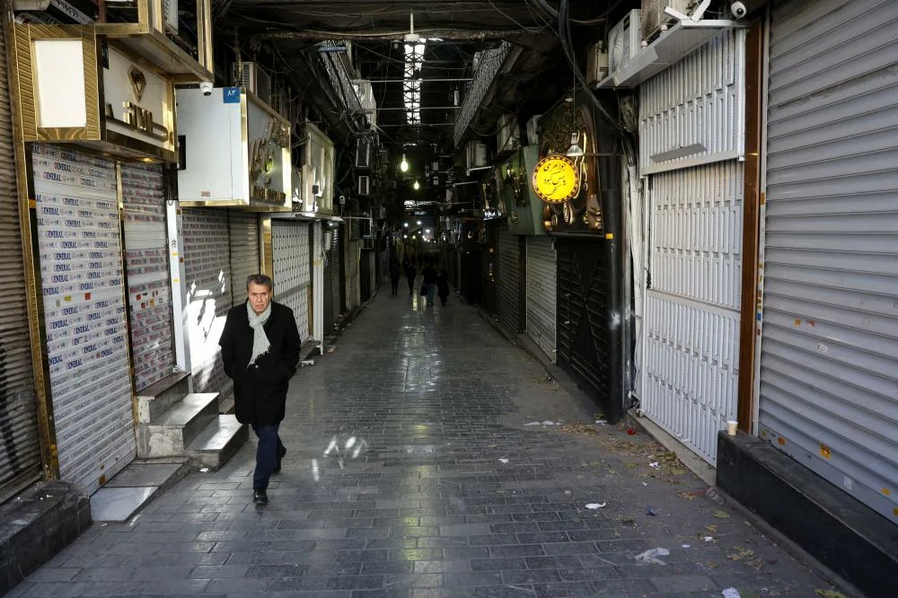 TehranPeoplewalkpastclosedshopsfollowingprotestsoveraplungeinthecurrencysvalueintheTehranGrandBazaarTehranIranDecember302025_585131